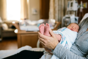 Newborn baby resting peacefully in maternity hospital celebrating miraculous fertility preservation after ovarian tumour treatment